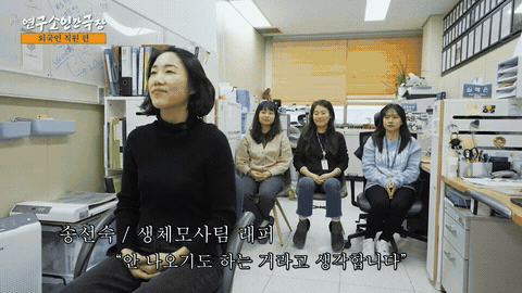 사무 공간에서 여러 사람이 나란히 앉아 이야기하는 장면