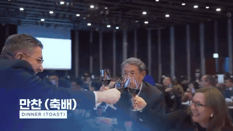 만찬 자리에서 참석자들이 잔을 들어 건배하는 장면